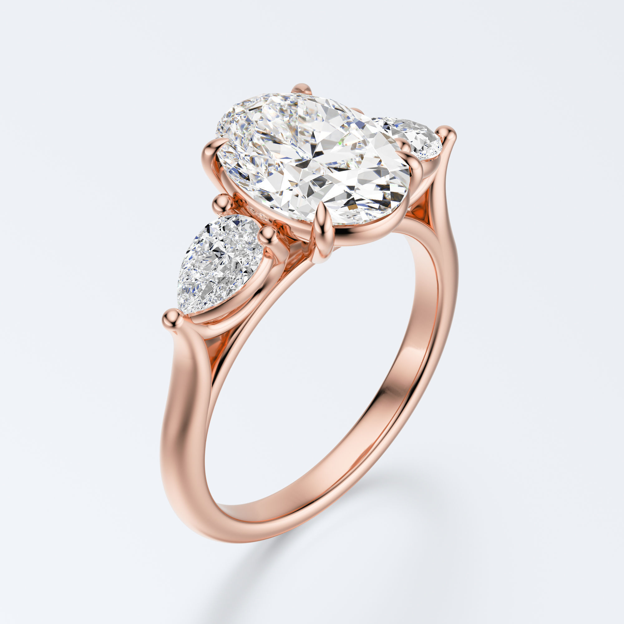 Rose gold three-stone oval and pear lab-grown diamond engagement ring three-quarter view