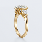 Yellow gold three-stone oval and pear lab-grown diamond engagement ring three-quarter view