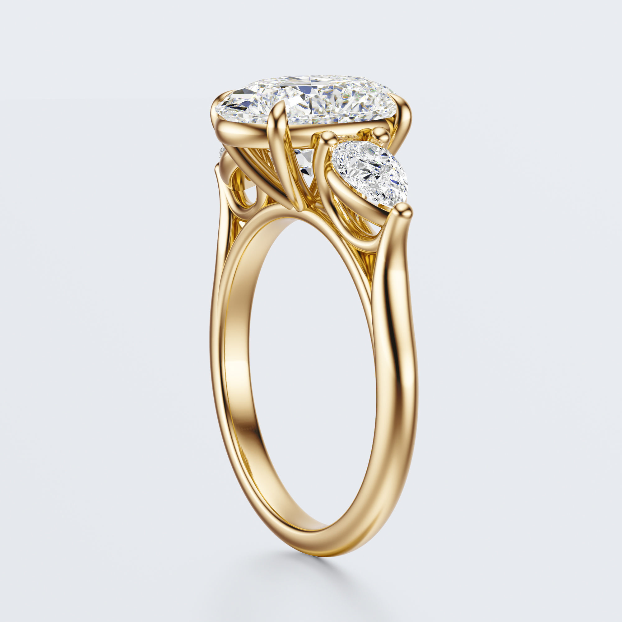 Yellow gold three-stone oval and pear lab-grown diamond engagement ring three-quarter view