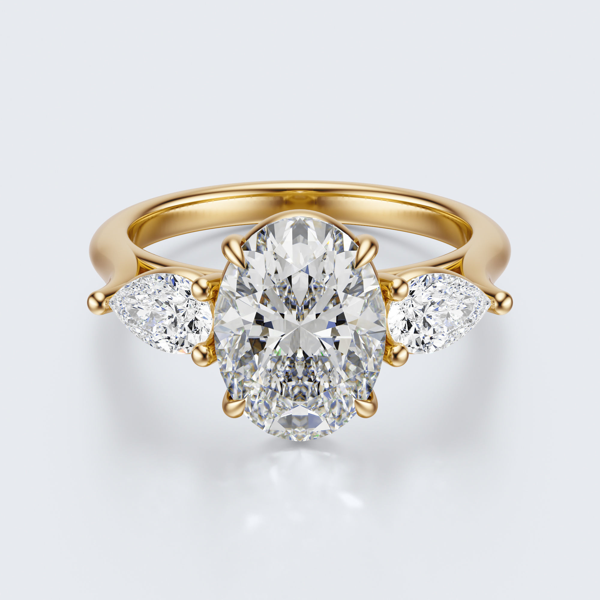 Yellow gold three-stone oval and pear lab-grown diamond engagement ring top view