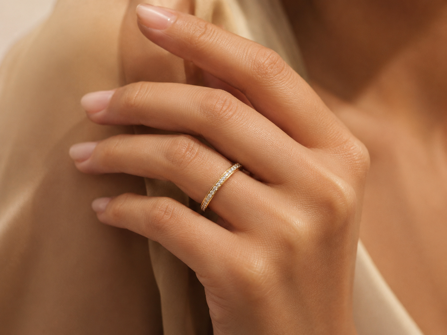 Infinity one-row lab grown diamond eternity band worn on hand in 14K yellow gold
